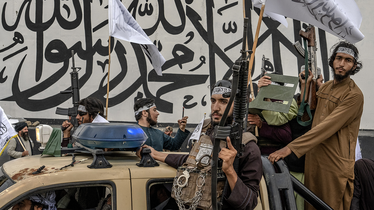 Taliban-Kämpfer in Lastwagen mit Waffen