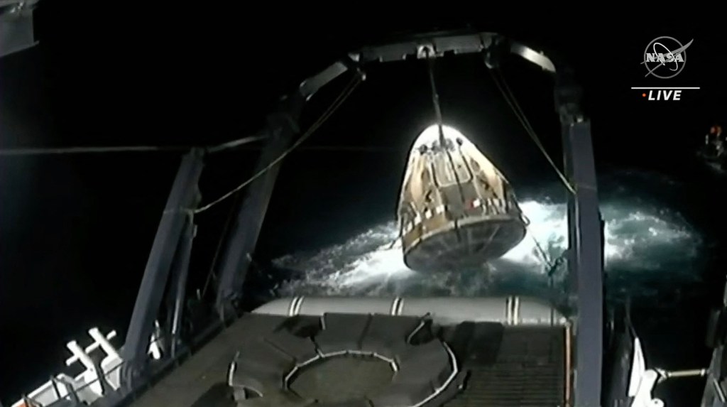 Dieser Screenshot aus dem Live-Feed der NASA zeigt die Raumsonde SpaceX Crew Dragon Endeavour, wie sie am 4. September 2023 nach einer Wasserspritze vor der Küste von Jacksonville auf das Bergungsschiff gehoben wird. 