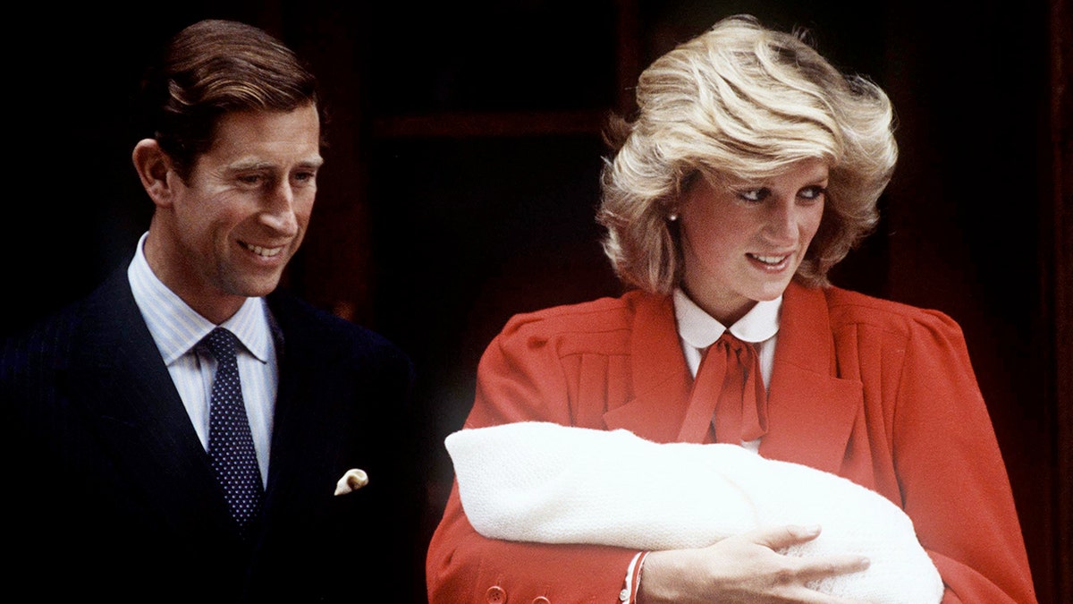 Prinzessin Diana trägt ein rotes Kleid und hält Prinz Harry nach seiner Geburt an der Seite von Prinz Charles