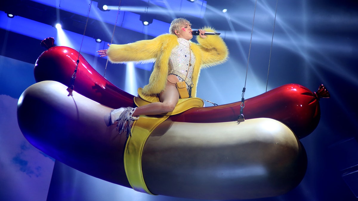 Miley Cyrus reitet einen Hotdog auf der Bühne 