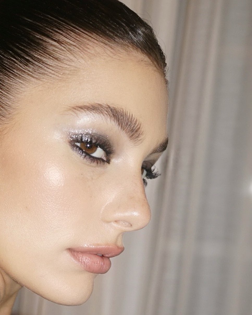 Camila Morrone close up with bushy brows and silver glitter disco eyeshadow '70s makeup trend