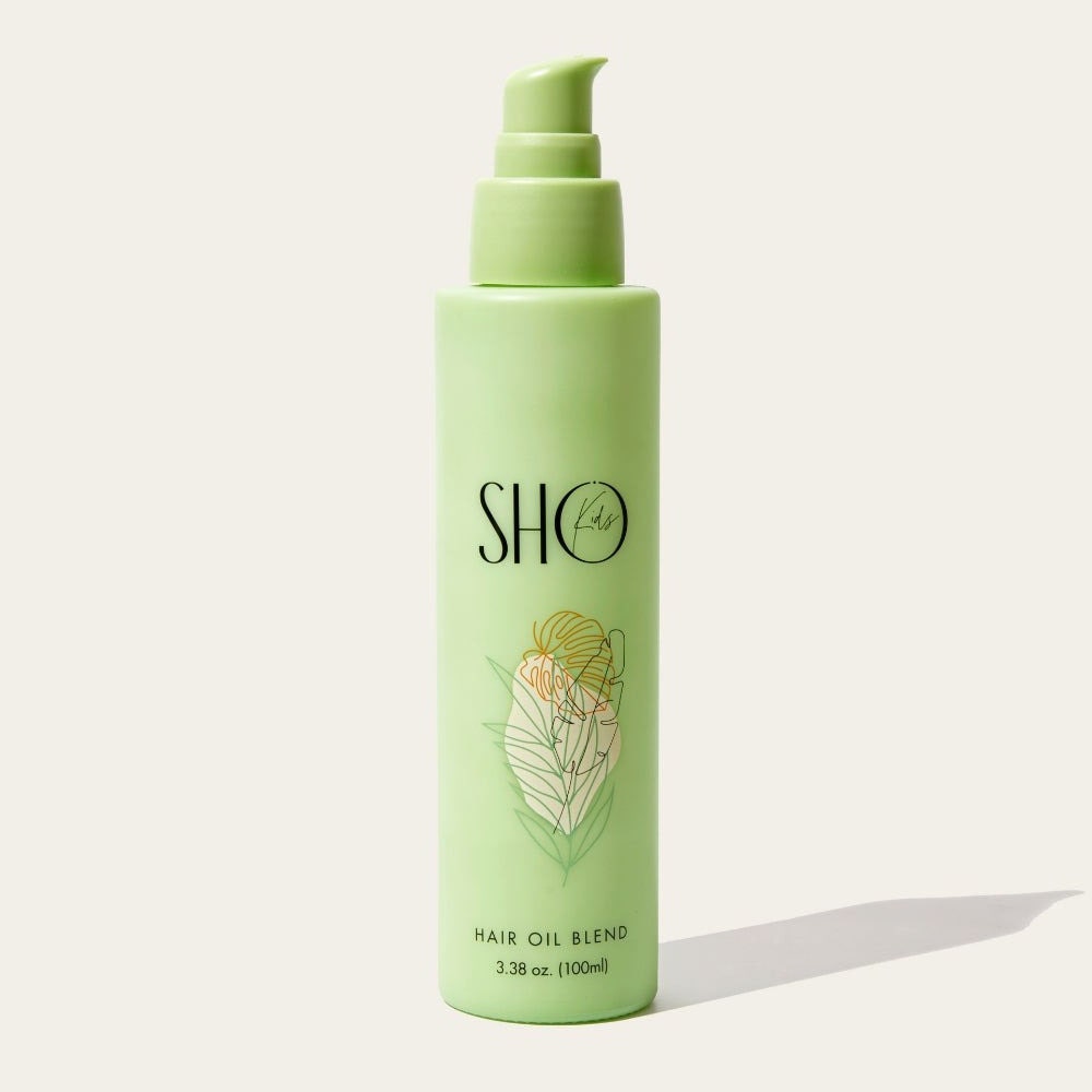 Sho Kids Hair Oil Blend grüne Pumpflasche auf grauem Hintergrund