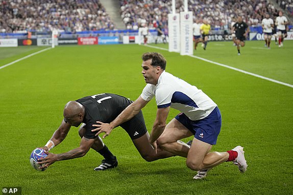 New Zealand's Mark Telea scores the opening try despite the challenge of France's Damian Penaud during the Rugby World Cup Pool A match between France and New Zealand at the Stade de France in Saint-Denis, north of Paris, Friday, Sept. 8, 2023. (AP Photo/Christophe Ena)