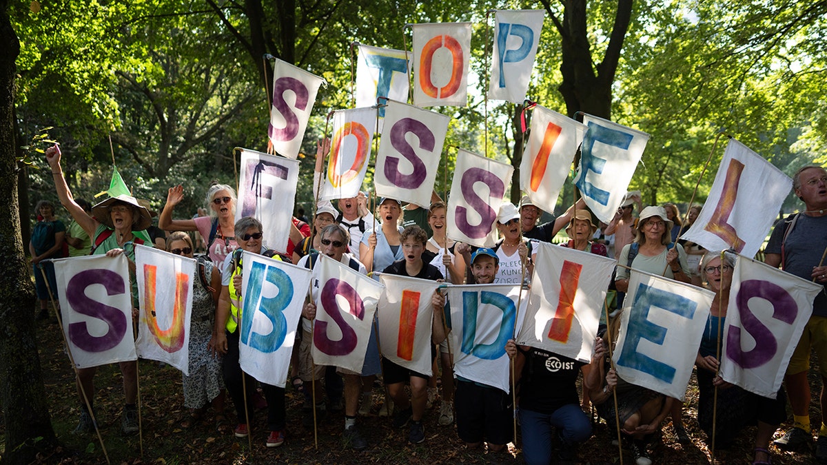 Demonstranten halten Buchstabenschilder mit der Aufschrift: "Stoppen Sie die Fossilsubventionen"