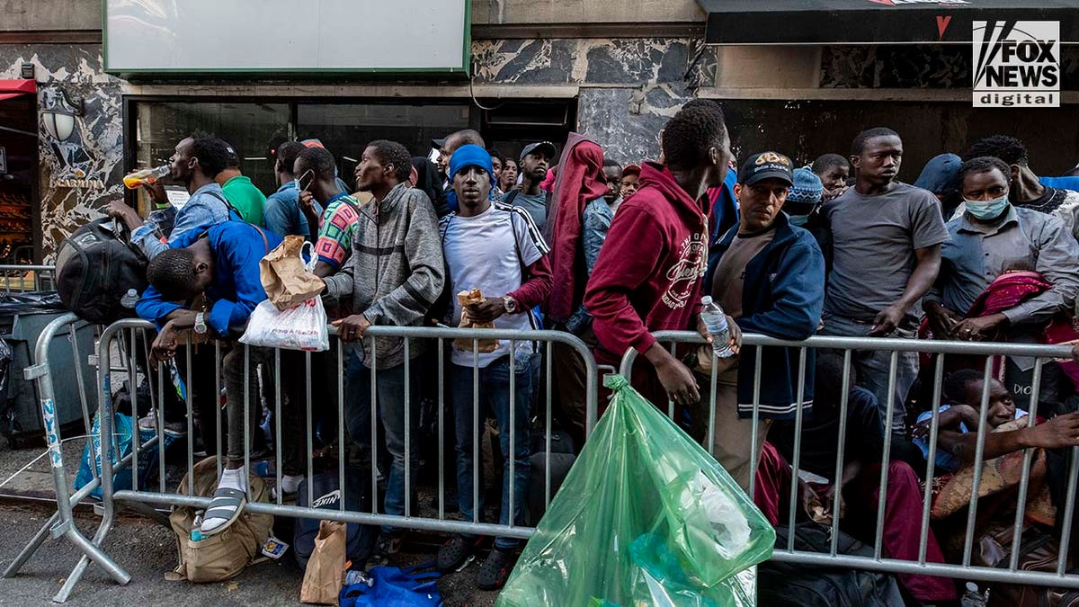 Migranten sitzen auf dem Bürgersteig in Manhattan