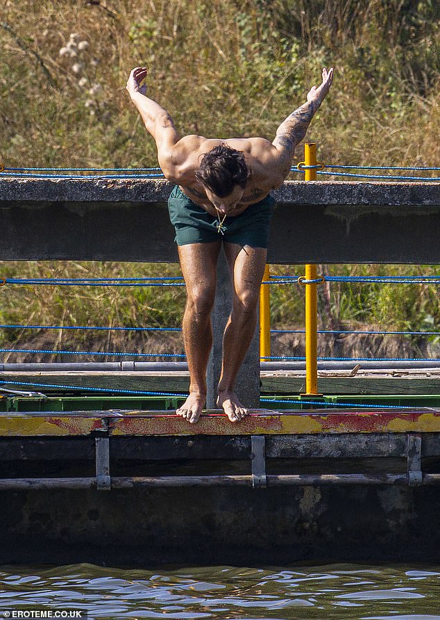 Schwimmen: Der Popstar stand mit den Füßen über dem Rand des Docks, bevor er sich ins Wasser stürzte