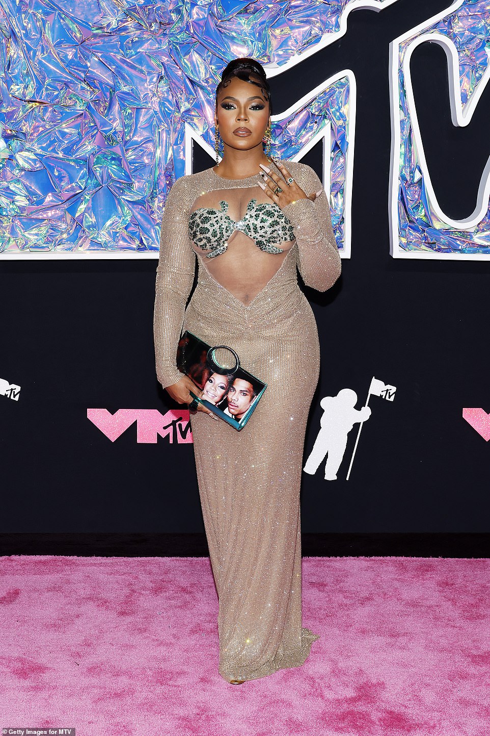Strike a pose: Ashanti opted for a sheer beige and aquamarine cut-out dress, adding a bag featuring an image of her and her boyfriend Nelly, confirming their rekindled romance