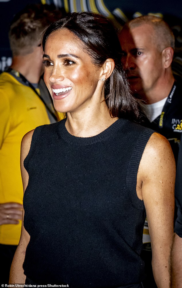 Meghan smiles to the crowds at an event last night