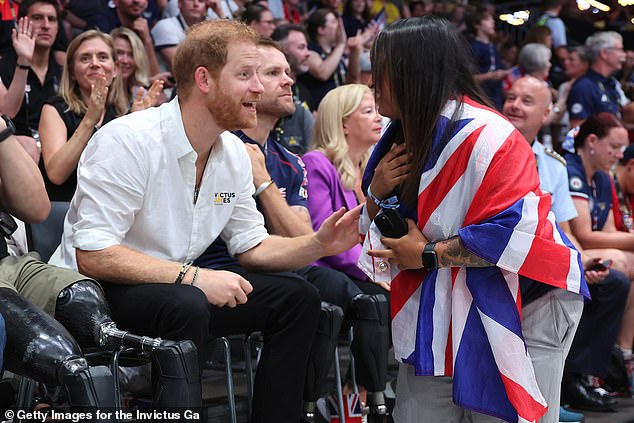 Prince Harry speaks enthusiastically to a Team GB supporter