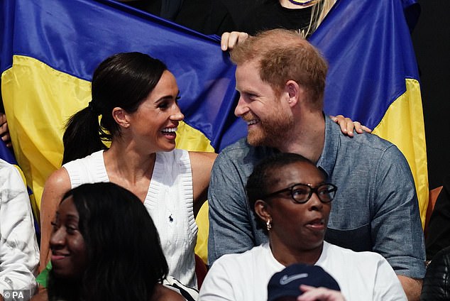 Die lächelnde Herzogin von Sussex legt bei den heutigen Spielen ihren Arm um ihren Ehemann Prinz Harry