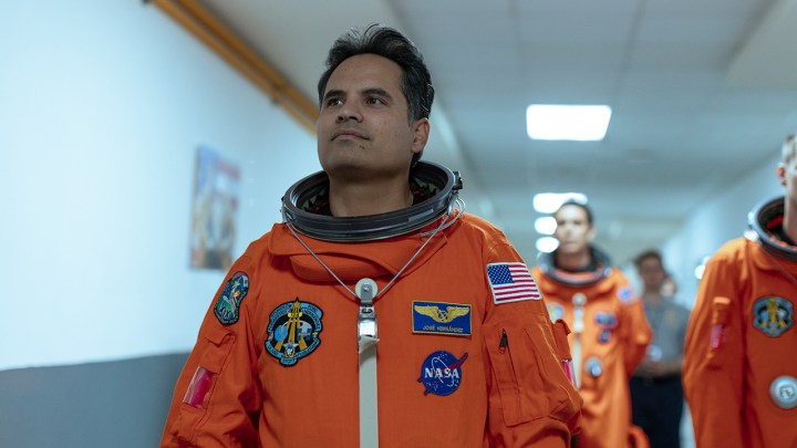 Michael Peña als José im Raumanzug, der im Film „A Million Miles Away“ durch einen Flur läuft.