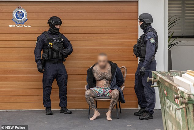 Mankaryous (Bild in der Mitte) wurde mit nichts als einem Umhang und Boardshorts bekleidet herausgezerrt, bevor er von Beamten der Raptor-Truppe abgeführt wurde