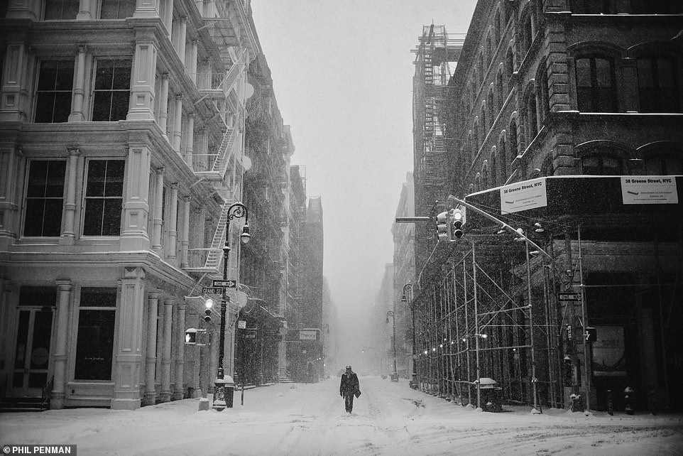 Ein Mann geht während eines Schneesturms im Februar 2021 eine leere Straße entlang