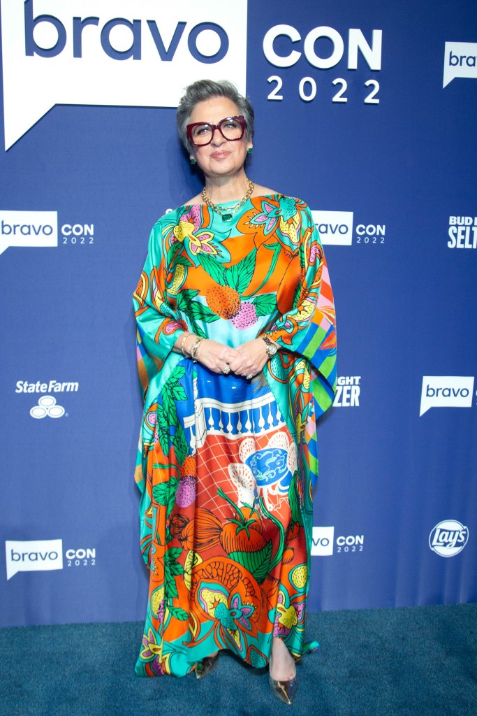 Full-length shot of Caroline Manzo in a bright, patterned caftan on the blue carpet at Bravo Con 2022.