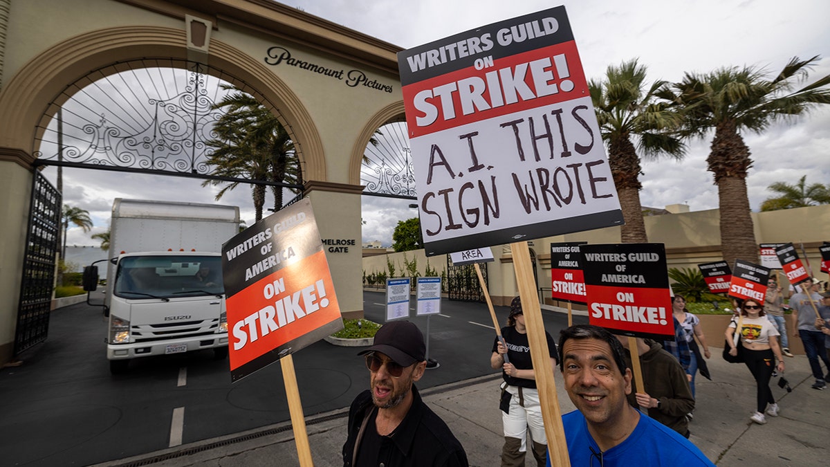 In Los Angeles streikende Schriftsteller tragen Schilder, die hervorheben, womit sie Probleme haben. Auf einem Schild steht: „ "AI DIESES SCHILD GESCHRIEBEN"