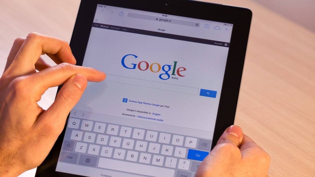 Die Person hält ihr iPad mit der Google-Suchseite auf dem Bildschirm