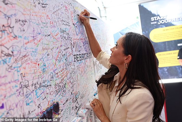 Am sechsten Tag der Invictus Games schreibt Meghan Markle ihre Unterschrift auf eine riesige Tribute-Wand voller Namen