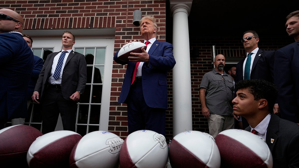Trump in Iowa hält einen Fußball in der Hand