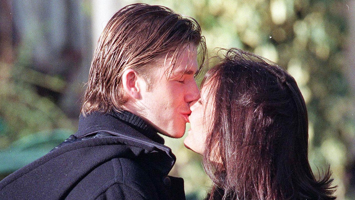 Victoria und David Beckham küssen sich 1998