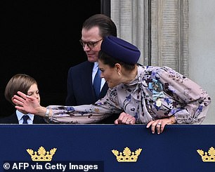 The Crown Princess lovingly fixes her son, Prince Oscar's hair as her husband Prince Daniel watches