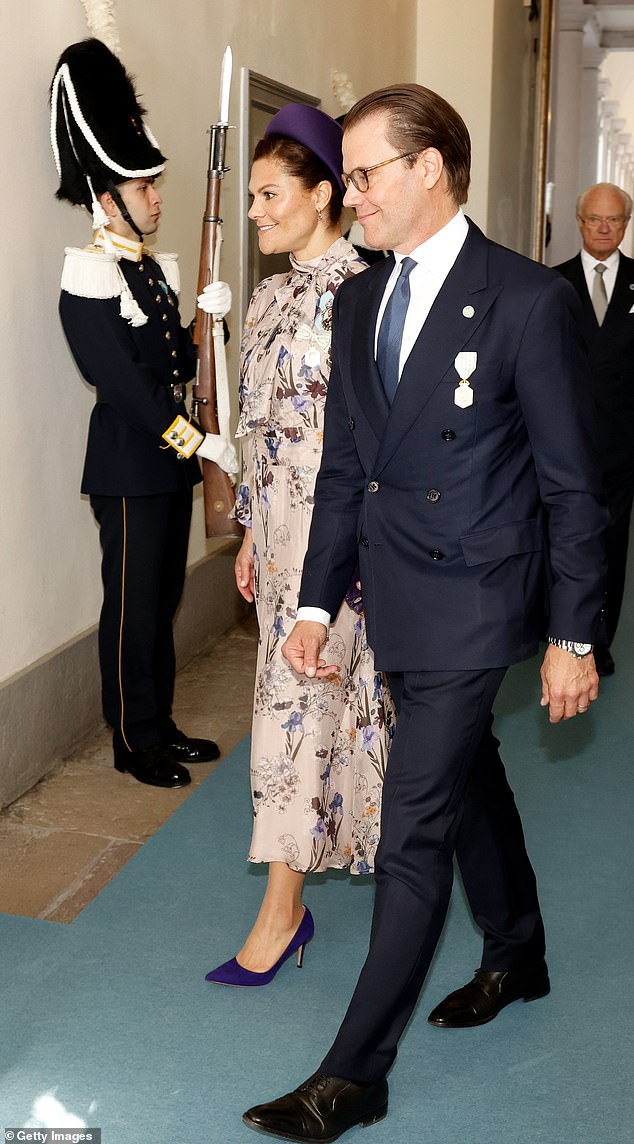 Victoria of Sweden (left), the eldest child of Gustaf, donned a summery floral ensemble for the occasion. While her husband, Prince Daniel of Sweden (right) opted for a double-breasted navy suit, a crisp white shirt, and a pale blue tie