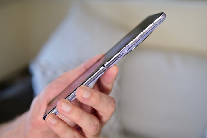 Eine Person hält das Tecno Phantom V Flip und zeigt die Seite des geöffneten Telefons.
