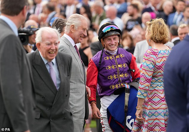 King Charles III speaks to jockey Tom Marquand before the Betfred St Leger Stakes during the Betfred St Leger Festival at Doncaster Racecourse.