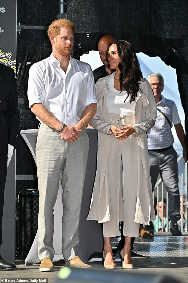 Meghan (right) dazzled in a Cuyana jacket and pants matched with a white tank top and Lanvin earrings