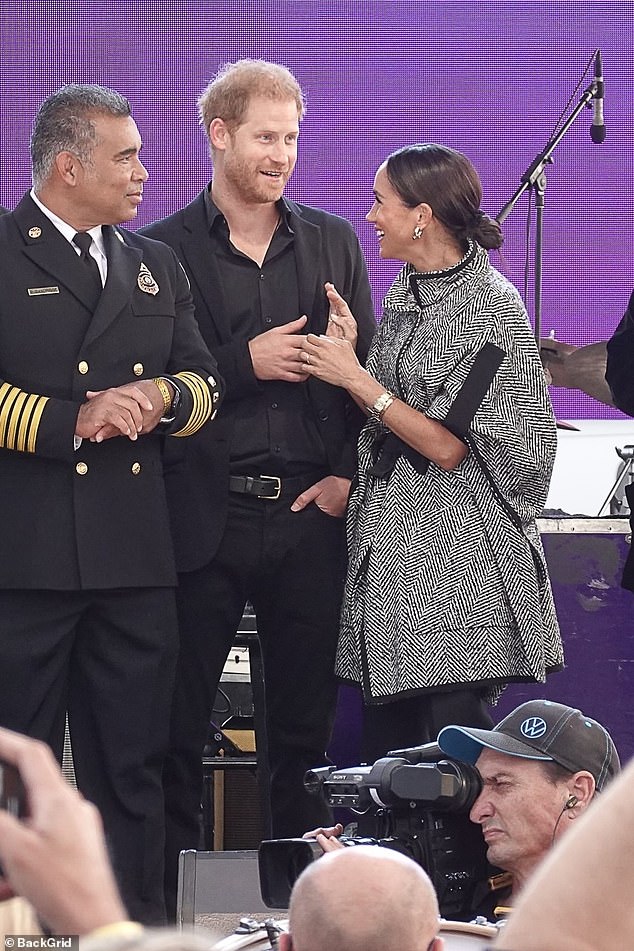 The Duchess beams at Prince Harry while they're introduced as special guests