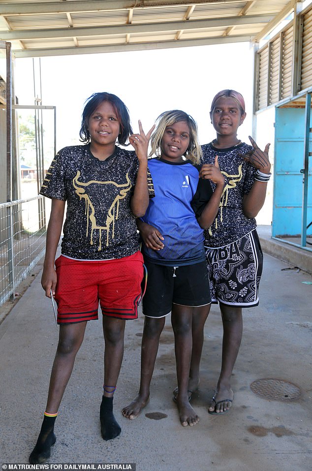 Pukatja, 450 km südlich von Alice Springs, ist die größte Gemeinde im Anangu Pitjantjatjara Yankunytjatjara (ausgesprochen arn-ahng-oo pit-jan-jah-jarra yan-kun-ja-jarra).  Drei Mädchen sind nach der Schule vor der Raststätte der Gemeinde abgebildet