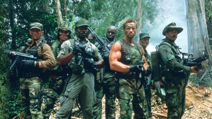 Die Besetzung von Predator posiert mit ihren Waffen im Dschungel.