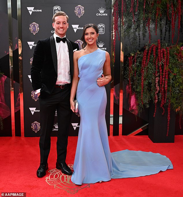 Essendon player Darcy Parish beamed as he posed alongside partner Grace Stanton who was gorgeous in powder blue