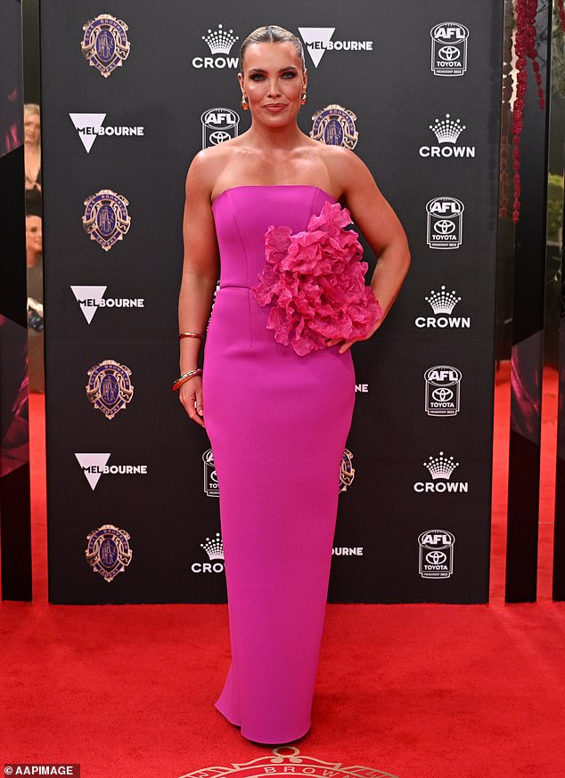 Abbey Holmes was pretty in pink, with the AFL player choosing a Barbie-inspired candy hue for her strapless, fitted frock that featured a large floral embellishment