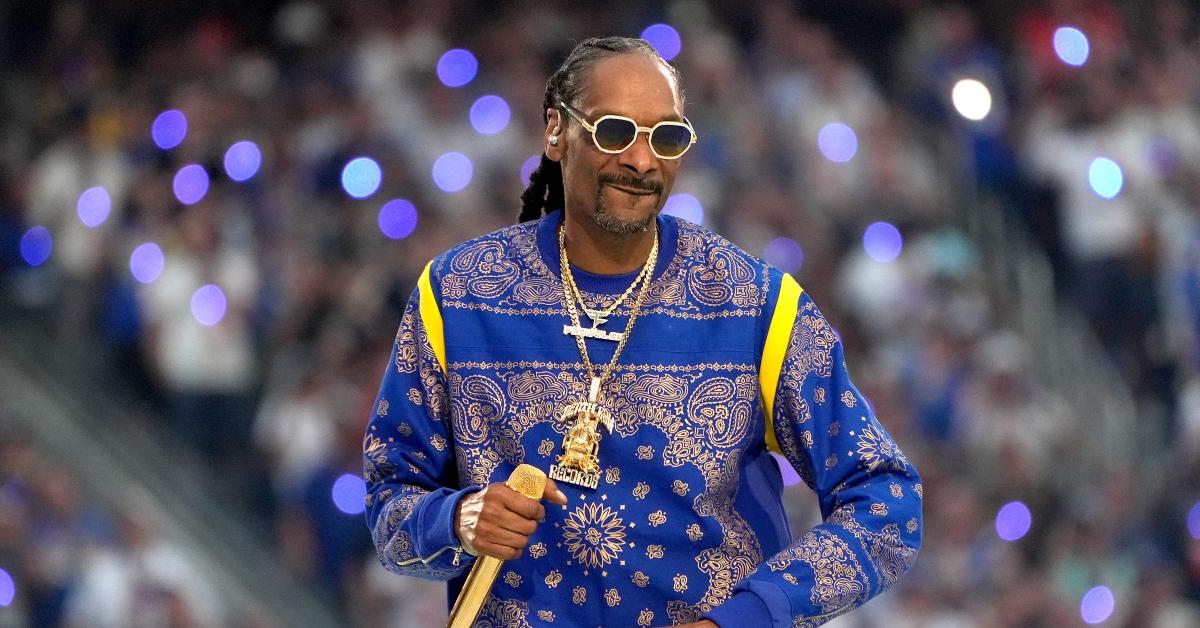 Snoop Dogg trägt ein blau-gelbes Sweatshirt mit einer riesigen goldenen Todestraktkette. 