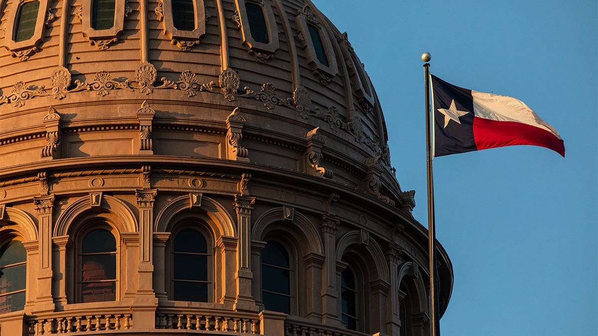 Kuppel des Texas Capitol-Gebäudes mit wehender texanischer Flagge davor.