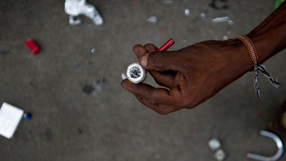Ein Drogenabhängiger hält eine Crackpfeife in der Hand
