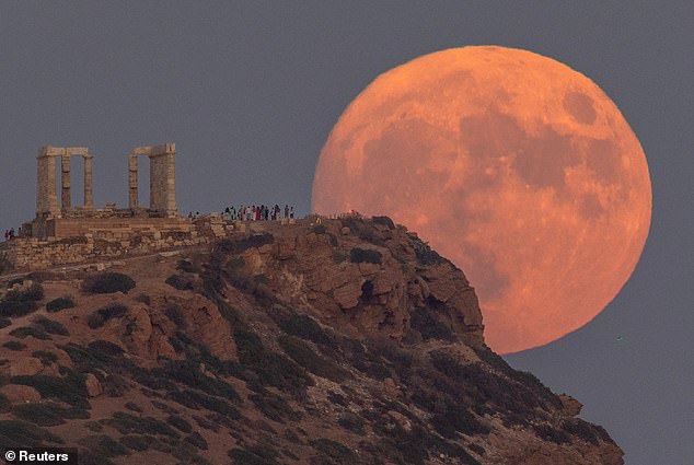 Ein Vollmond, bekannt als der Blaue Mond, geht am 30. August 2023 hinter dem Tempel des Poseidon am Kap Sounion in der Nähe von Athen, Griechenland, auf