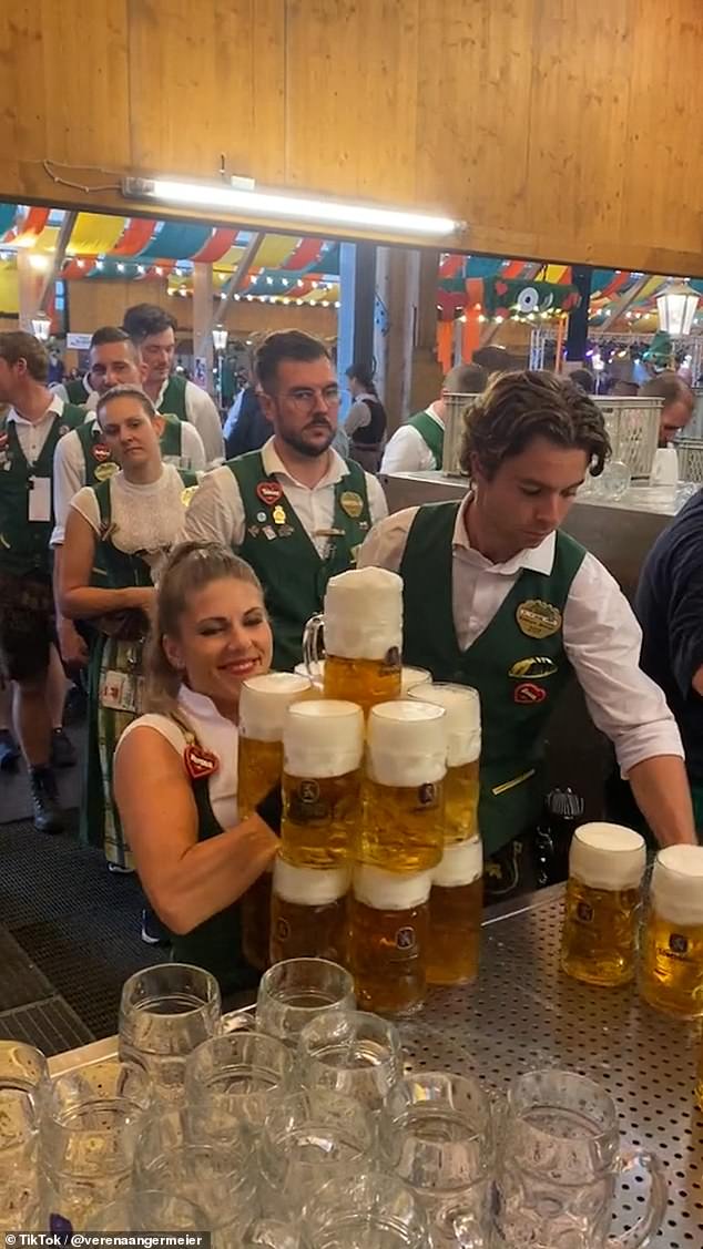 Superstark!  Dies ist der unglaubliche Moment, in dem eine Oktoberfestkellnerin (im Bild) satte 13 Biere gleichzeitig trug, bevor sie sie den Kunden servierte