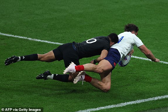 France's right wing Damian Penaud is tackled by New Zealand's fly-half Richie Mo'unga during the France 2023 Rugby World Cup Pool A match between France and New Zealand at Stade de France in Saint-Denis, on the outskirts of Paris on September 8, 2023. (Photo by Thomas SAMSON / AFP) (Photo by THOMAS SAMSON/AFP via Getty Images)