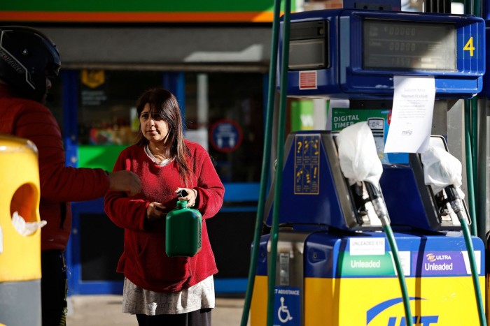 Eine Frau hält einen Benzinkanister in Leyton im Osten Londons