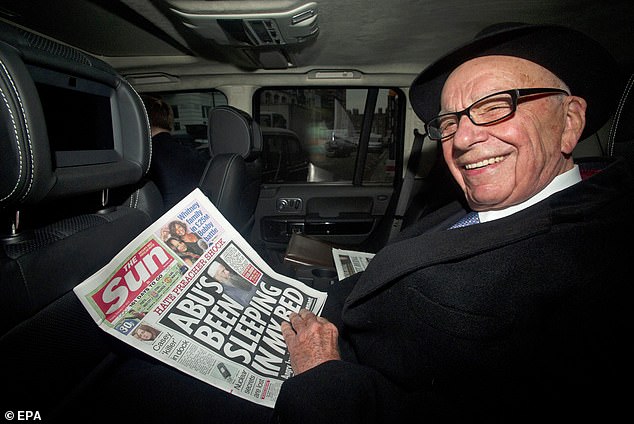 News Corp Chairman Rupert Murdoch leaves his house in London holding a copy of The Sun newspaper