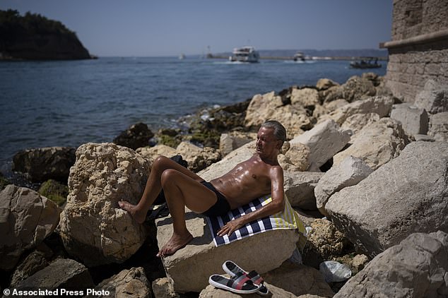 A man sunbathes in high temperatures in Marseille, southern France, August 19, 2023. UN weather agency says Earth sweltered through the hottest summer ever as record heat in August capped a brutal, deadly three months in northern hemisphere