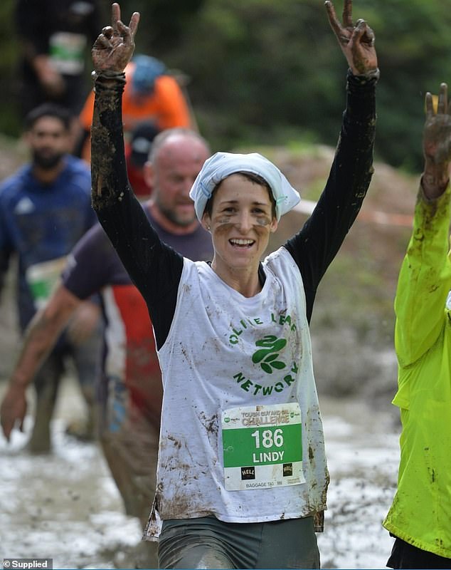 Lindy Jacomb wearing a headscarf as a symbol of religious groups while doing the Mud Run obstacle race as an awareness fundraiser for her Olive Leaf Network