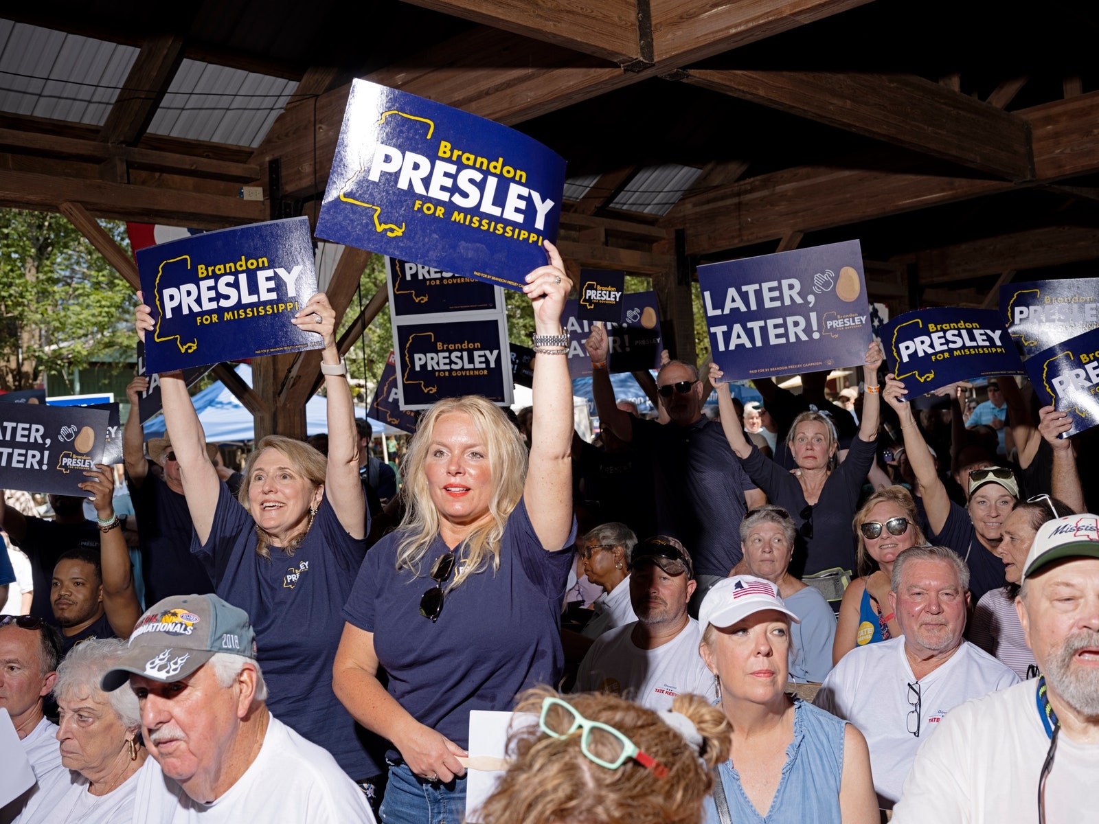 Eine Gruppe von Menschen hält Schilder mit der Aufschrift „Brandon Presley für Mississippi“ hoch.