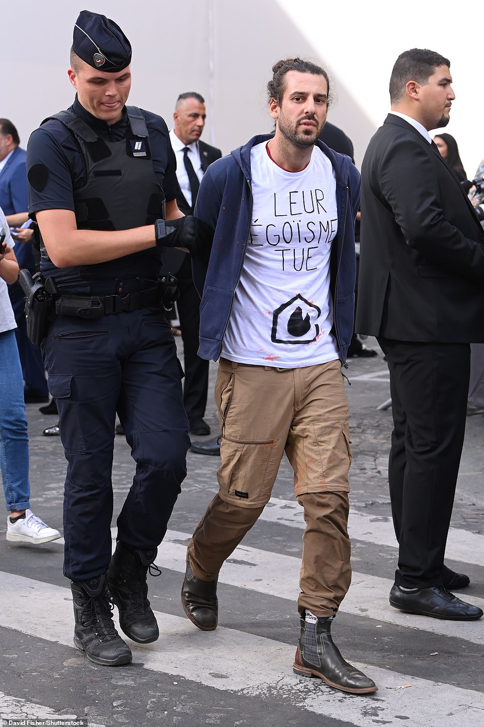 Protest: Auf dem Bild wurde ein Demonstrant von der Polizei abgeführt, nachdem vor der Louis Vuitton Show orangefarbene Farbe geworfen wurde