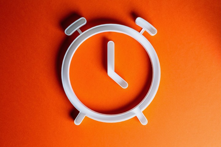 Auf einem orangefarbenen Hintergrund wird eine Uhr angezeigt.