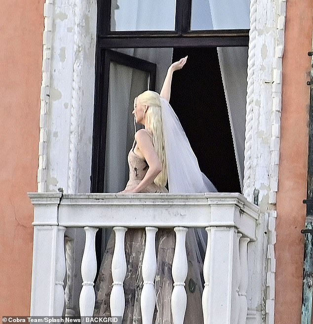 Die Schauspielerin winkte, als sie sich umdrehte und den venezianischen Balkon verließ, um den Fans einen Blick auf ihren traditionellen bodenlangen weißen Schleier zu gewähren