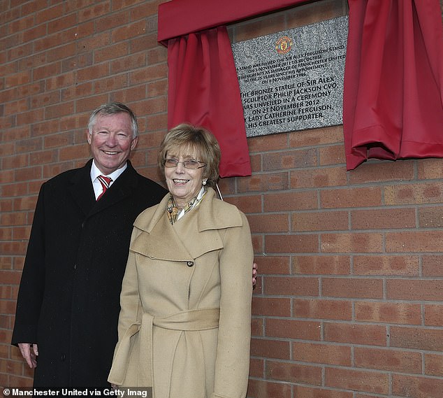 Das Paar posiert vor einer Gedenktafel, die ihre Anwesenheit bei der Enthüllung einer Statue von Sir Alex in Manchester ankündigt