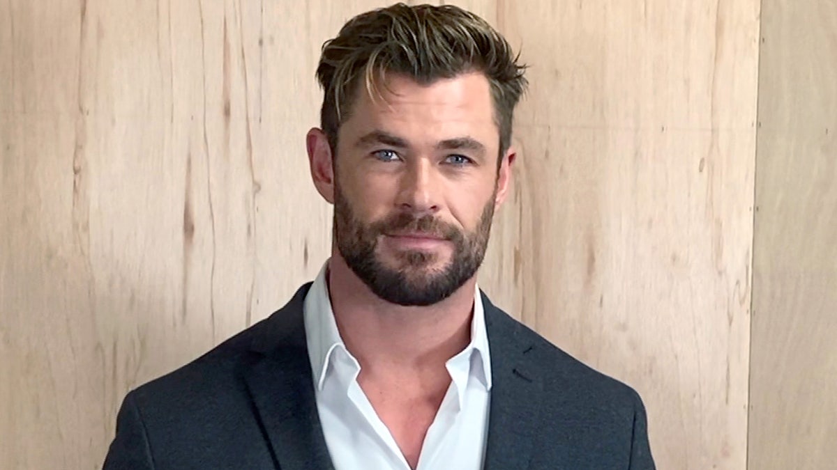 Chris Hemsworth posiert für die Porträtsitzung in Anzugjacke und Button-Down-Hemd