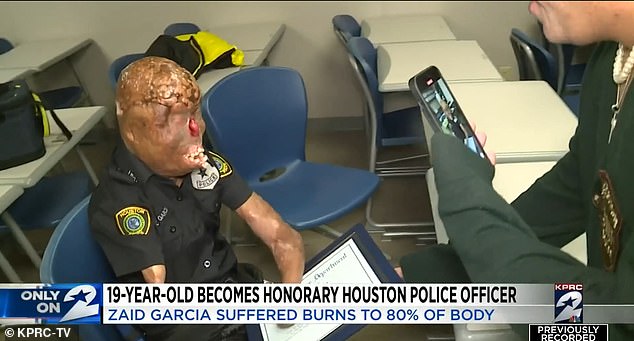 Herr Garcia ist oben abgebildet, nachdem ihm eine Urkunde überreicht wurde, die ihn zum Ehrenmitglied der Houstoner Polizei macht